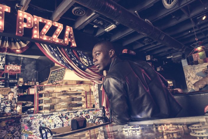 Jerry Metellus ad campaigns lifestyle photography. One day in downtown Las Vegas. Portrait photography at evil pie pizza of young guy in leather coat.