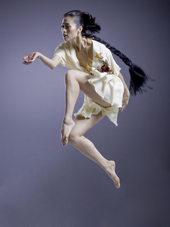 Jerry Metellus dance photography at JM Studios Las Vegas. Contemporary photography of a female ballet dancer with a long black braided ponytail. Jete was captured in mid-air with her hand extended.