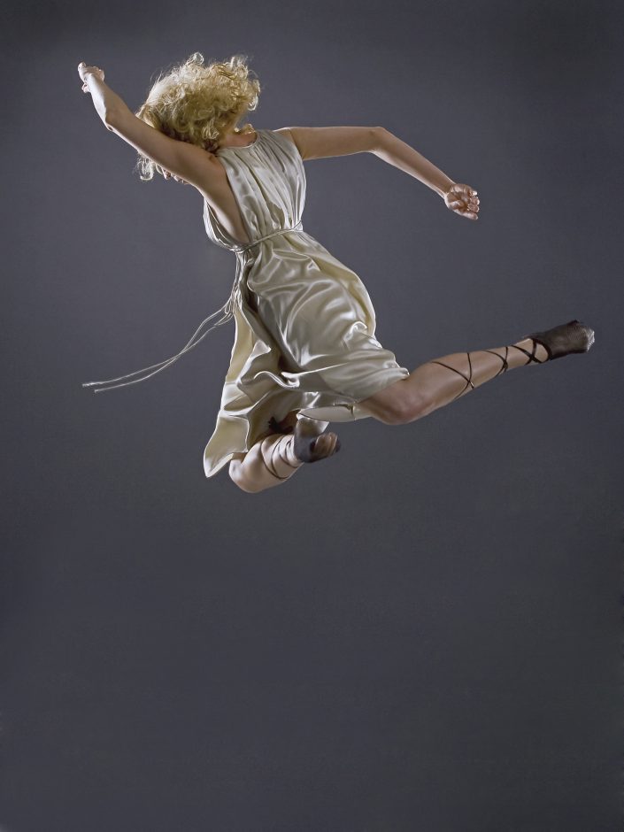 Jerry Metellus dance photography at JM Studios Las Vegas. Contemporary photography of female ballet dancer Jete captured in mid-air leaping to the left facing away from the camera.