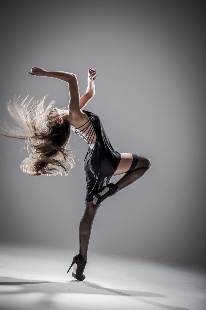 Jerry Metellus dance photography at JM Studios Las Vegas. Contemporary dance photography of a female dancer in black heels and an open-back dress throwing herself backward.